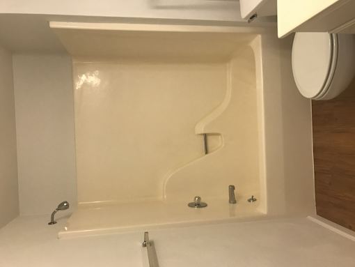 A white bathroom with a white tub and a white toilet.