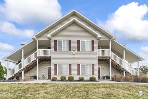 the front of a house with a porch and stairs