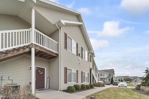 the front of a house with a porch and a sidewalk