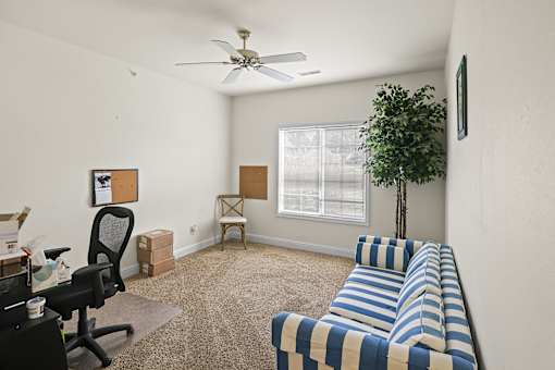 a living room with a couch and a ceiling fan