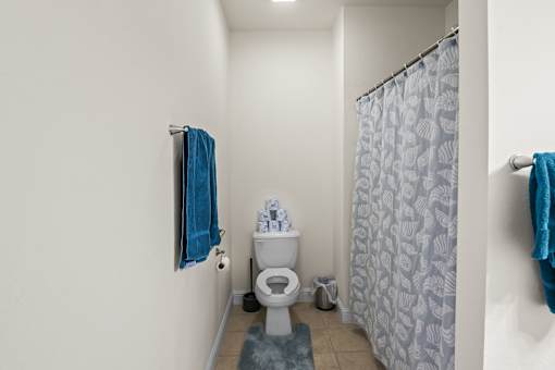 a bathroom with a toilet and a shower curtain