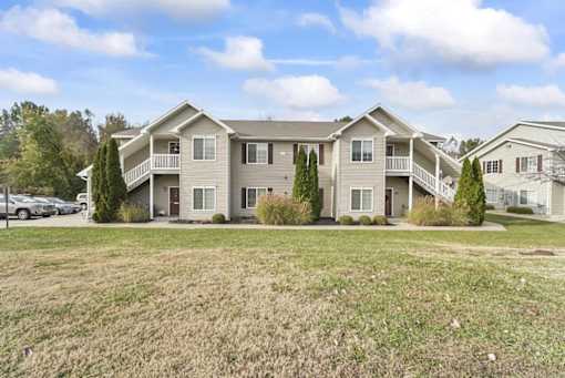 the view of an apartment building with a grass field