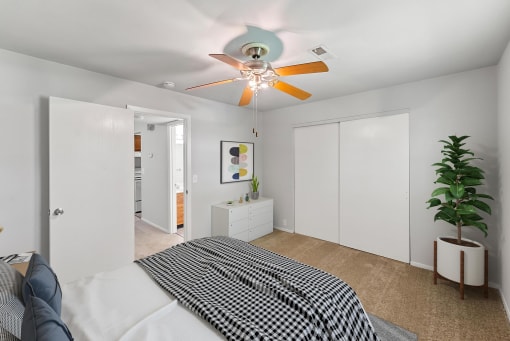 a bedroom with a ceiling fan and white walls