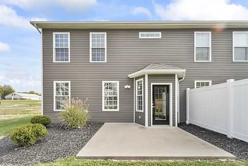 the front of a gray house with a concrete driveway
