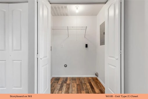 A white closet with a wooden floor and a white door.