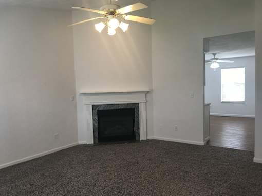 A room with a fireplace and a ceiling fan.