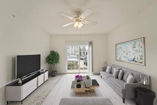 a living room with a gray couch and a ceiling fan