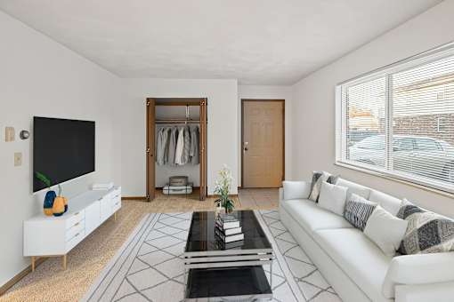 A living room with a white couch, a black coffee table, and a large mirror.