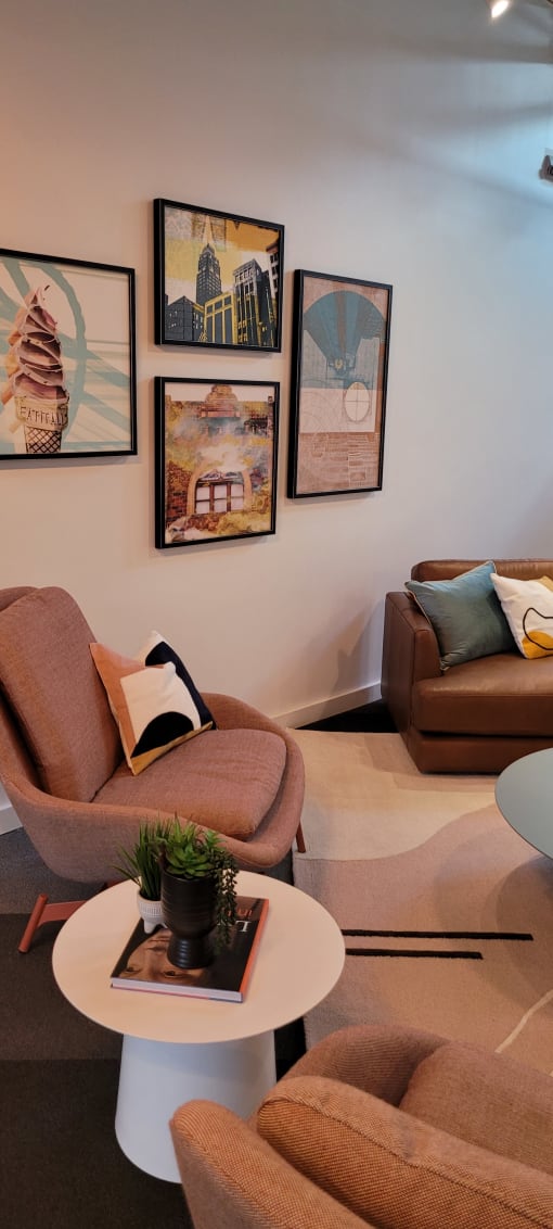 a collection of art hangs on a wall next to a chair