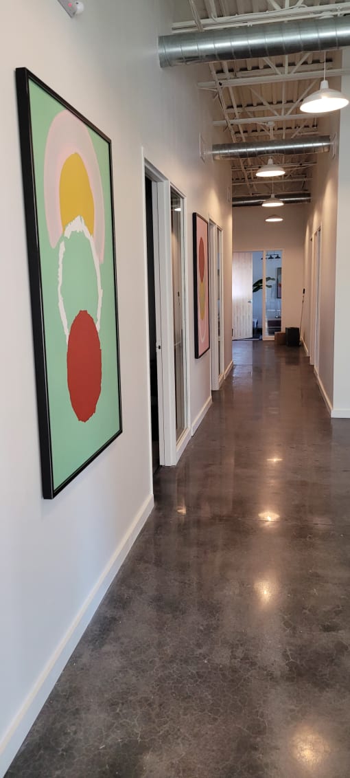 a view of the gallery space with paintings on the floor and a staircase in the background