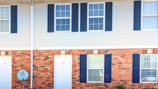 A red brick house with white doors and windows.