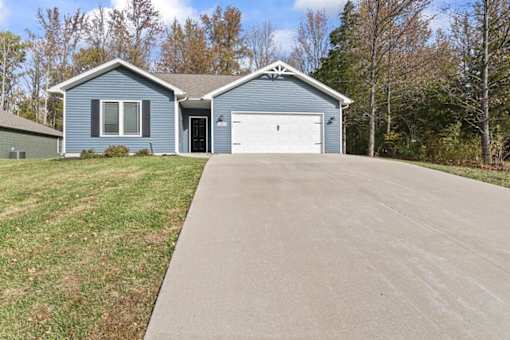 a blue house with a driveway and a white garage door