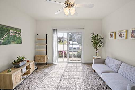 a living room with a couch and a ceiling fan