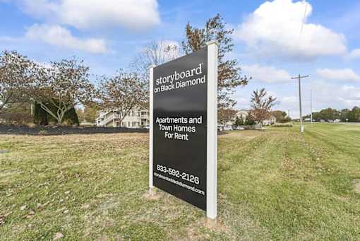 a sign in the middle of a grass field