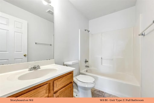 A white bathroom with a sink, toilet and bathtub.