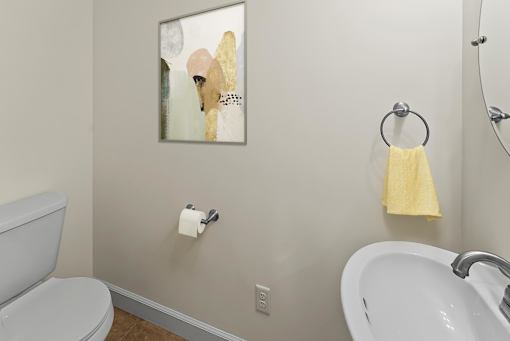 a bathroom with a sink and toilet and a painting on the wall