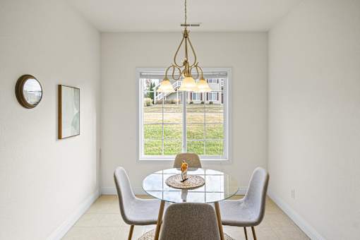a dining room with a table and chairs and a window