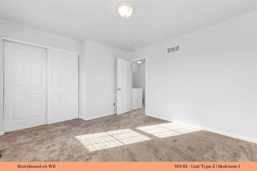 A bedroom with a carpeted floor and white walls.