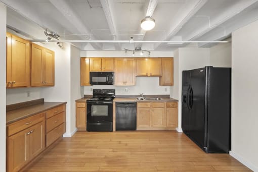a kitchen with a black refrigerator freezer and a black stove top oven