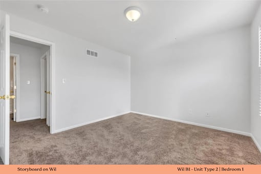 A room with a carpeted floor and a door on the left.