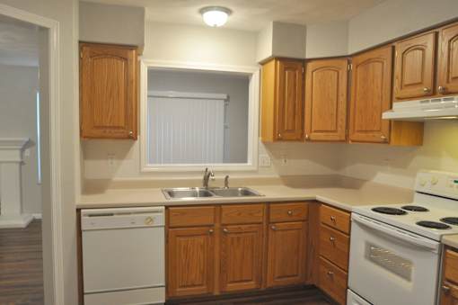 A kitchen with wooden cabinets and white appliances.