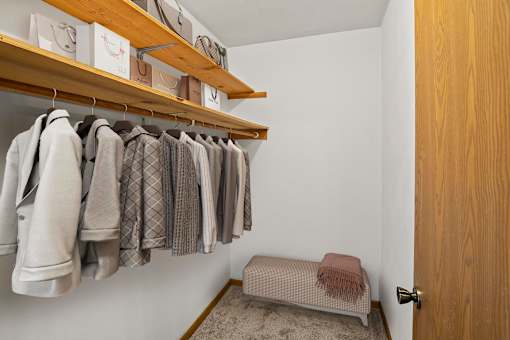 A row of clothes hanging on a rack in a room.