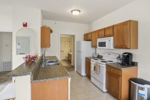 a kitchen with white appliances and granite counter tops