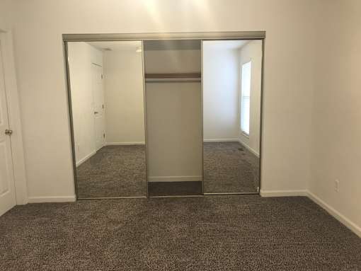 A large mirror in a room with carpeted floor.