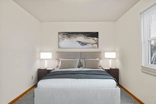A bedroom with a large bed and a painting above it.