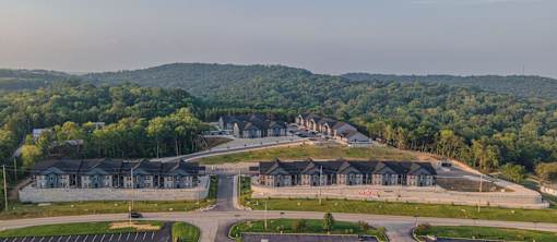 A large building complex surrounded by a forest.