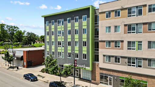 A green and beige building with a sign that says "Board" on it.