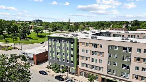 A view of a parking lot and two buildings from above.