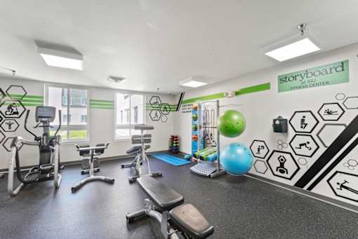 A gym with a variety of equipment including a treadmill, exercise bike, and weights.