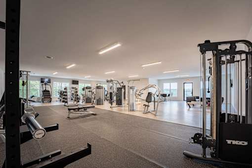 A gym with a variety of equipment including weights and machines.