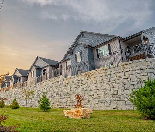 A row of houses with stone walls in front.