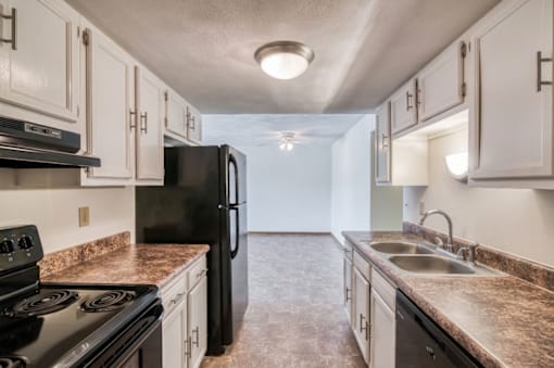 A kitchen with black appliances and granite countertops.