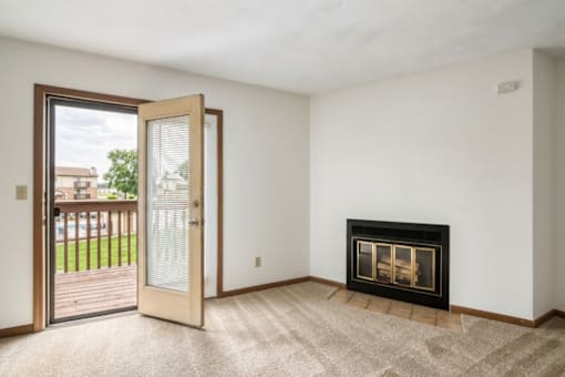 A room with a fireplace and a door leading to a balcony.