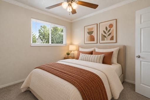 A bedroom with a large bed and a ceiling fan.