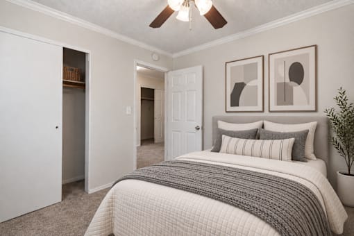 A bedroom with a large bed and two pictures on the wall.