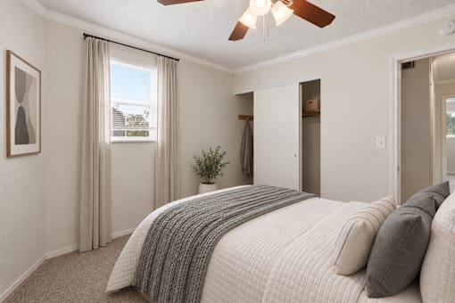 A bedroom with a large bed and a ceiling fan.