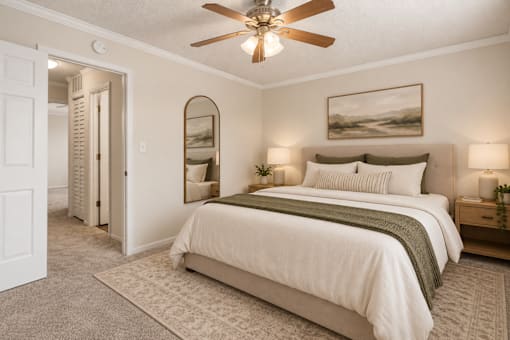 A bedroom with a large bed and a ceiling fan.
