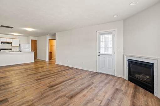A room with a fireplace and wooden floors.