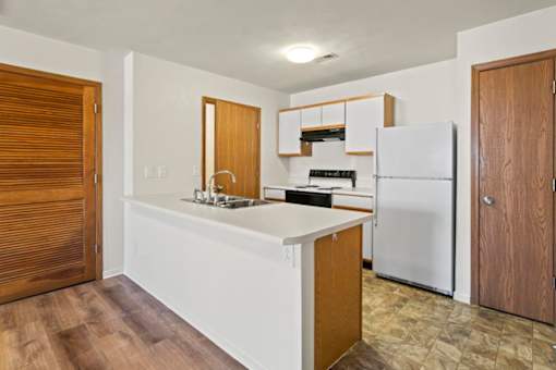 A kitchen with a white countertop and a white refrigerator.
