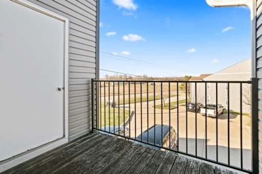 A balcony with a black railing and a white door.