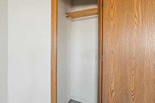 A white door is open to a room with a wooden door.