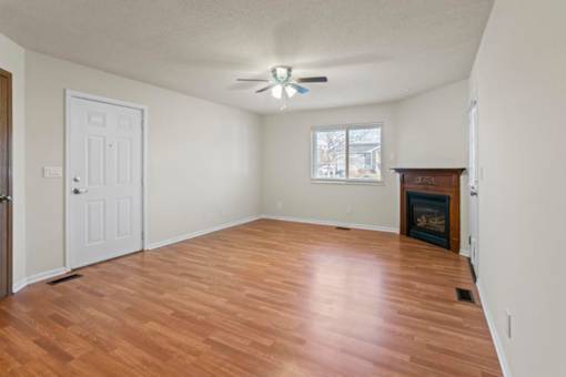 A room with a fireplace and a ceiling fan.