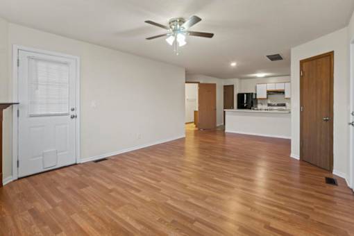 A room with wooden floors and a ceiling fan.