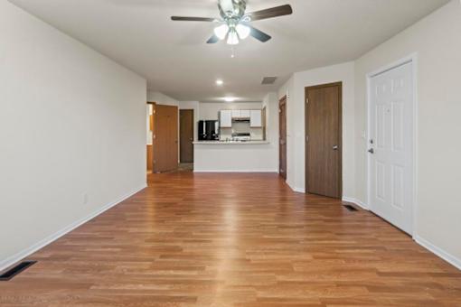 A room with wooden floors and a ceiling fan.