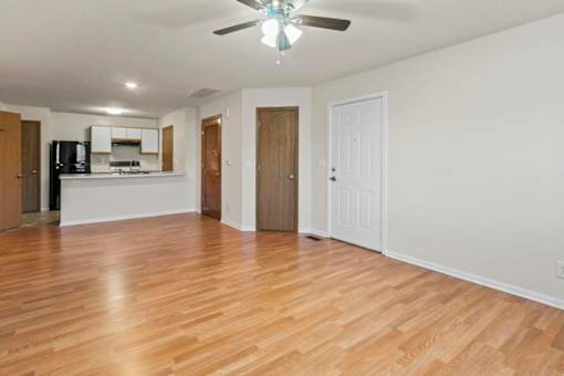 A room with wooden floors and a ceiling fan.