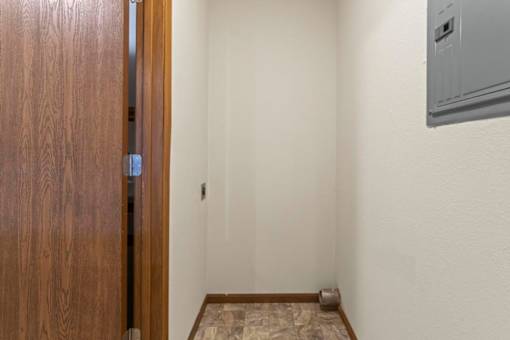 A room with a wooden door and a tiled floor.